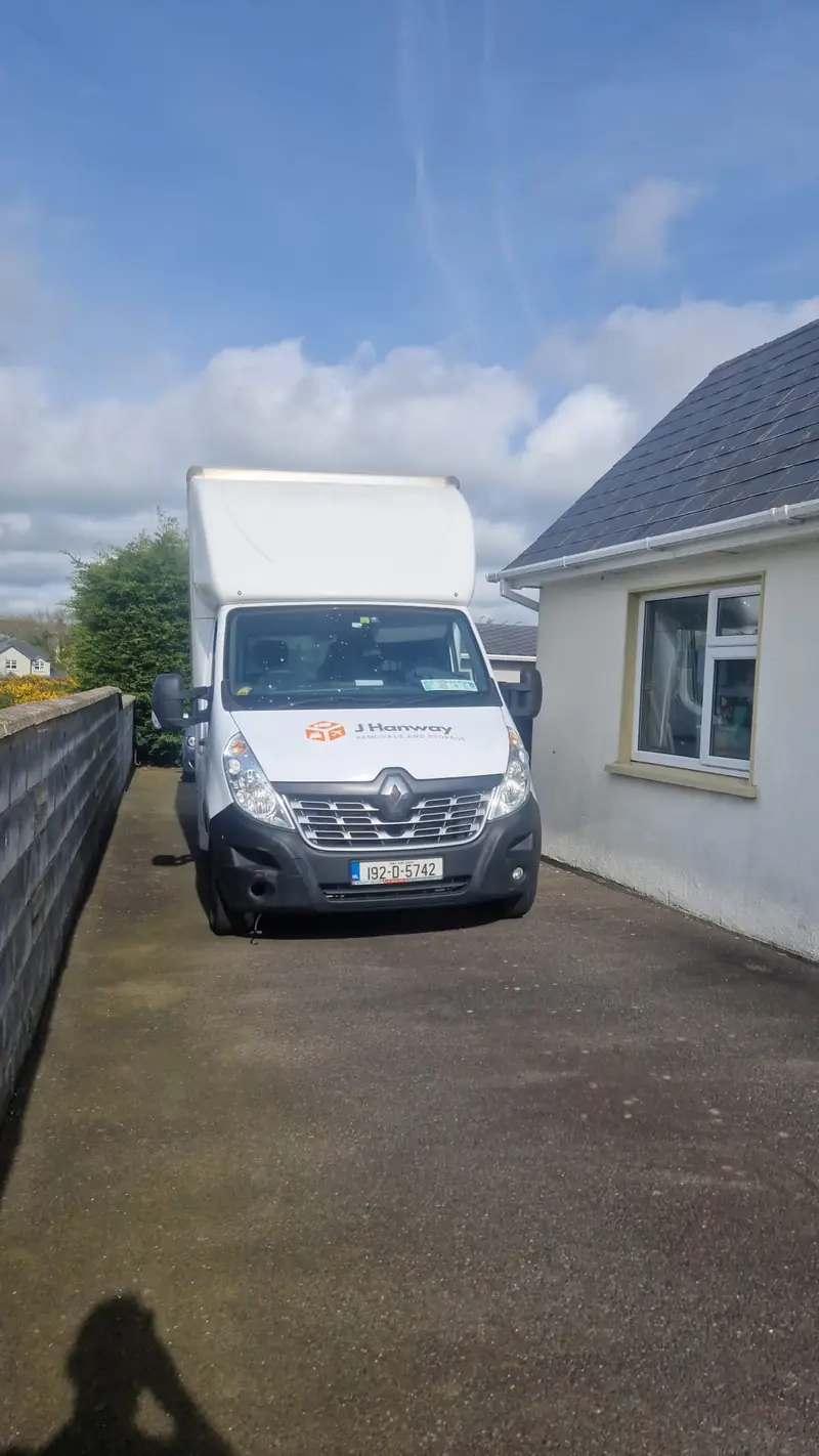 A Hanway van parked in a narrow driveway beside a house